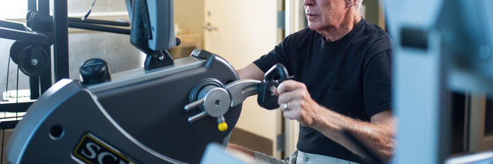 man using arm strength machine at physical therapy