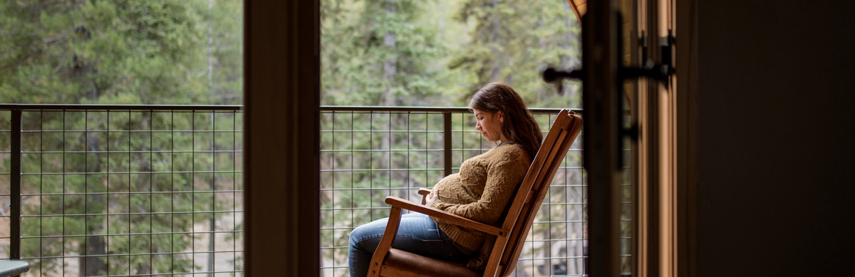 pregnant woman sitting in a rocking chair outside