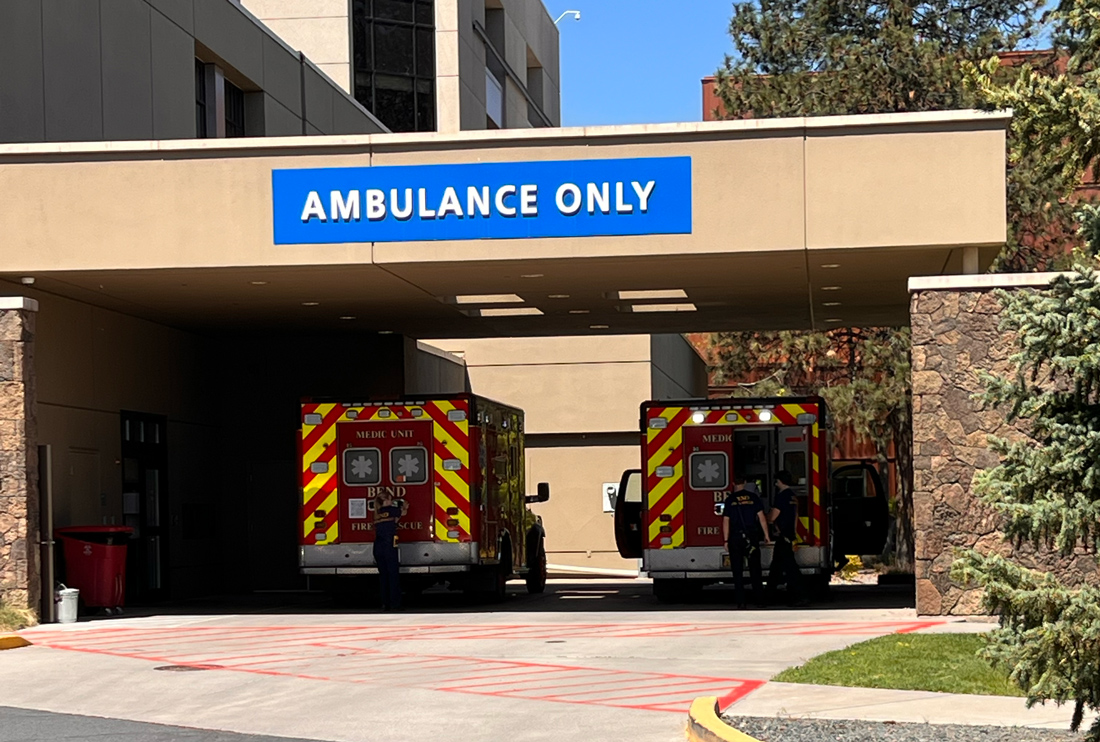 two ambulances sit at the Emergency Department entrance of St. Charles Bend