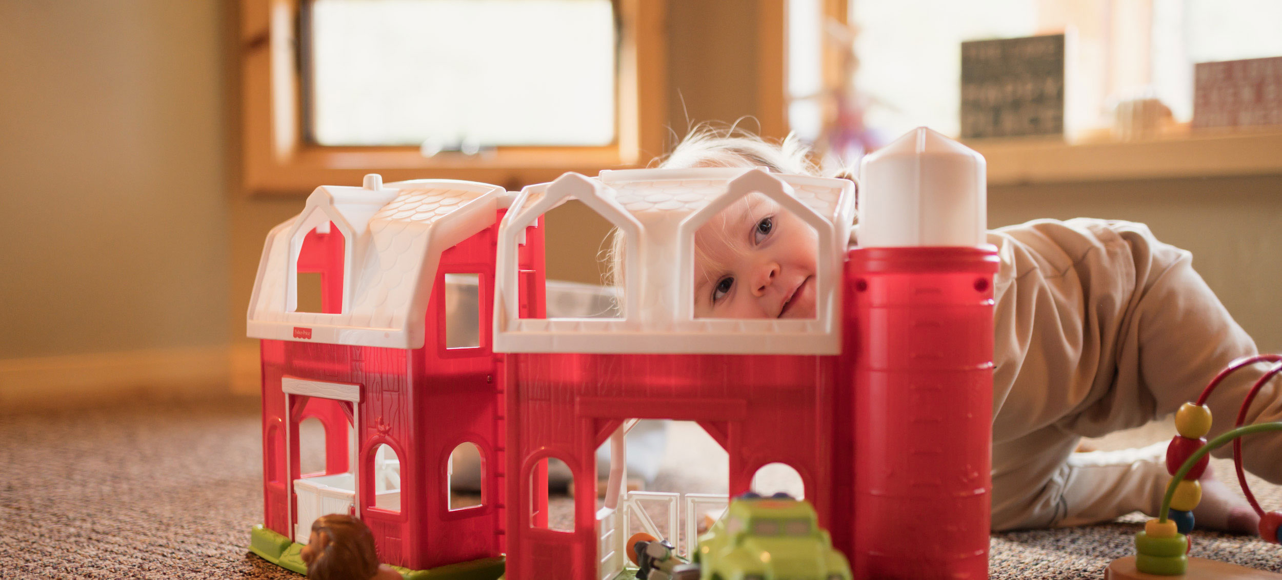 baby playing with toy barn