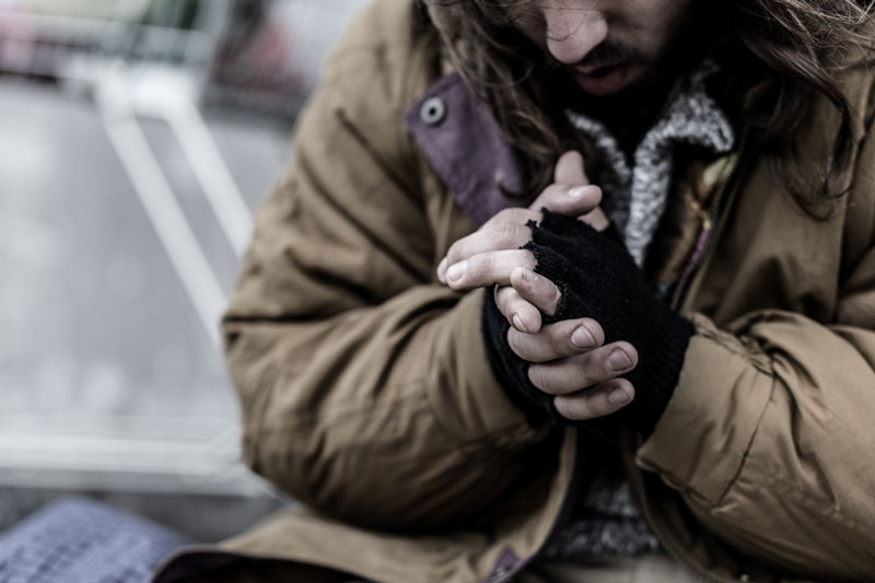homeless man warming hands