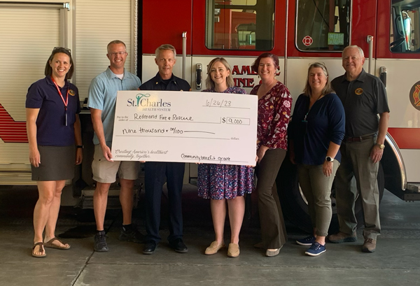 Staff from Redmond Fire and Rescue accept check from St. Charles - June 26, 2023