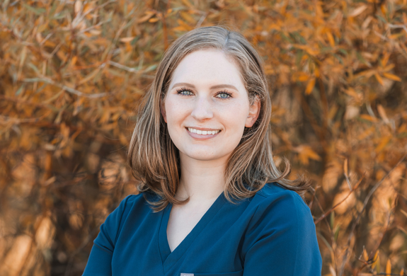 Lucy Lawrence standing outside in the folliage