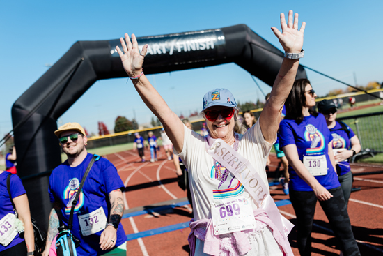 Breast cancer survivor celebrates as they cross the finish line at the Heaven Can Wait 5K.