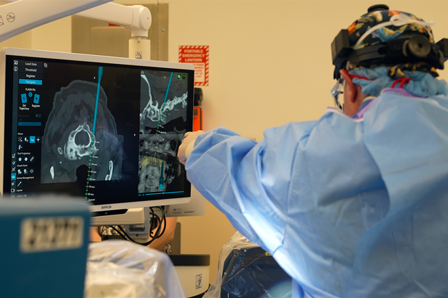 surgeon pointing at screen using spinal navigation