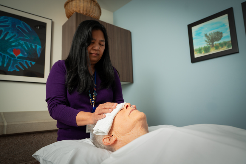 Volunteer provides reiki therapy to cancer patient