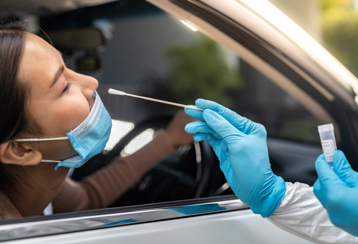 woman getting a COVID test through her car window