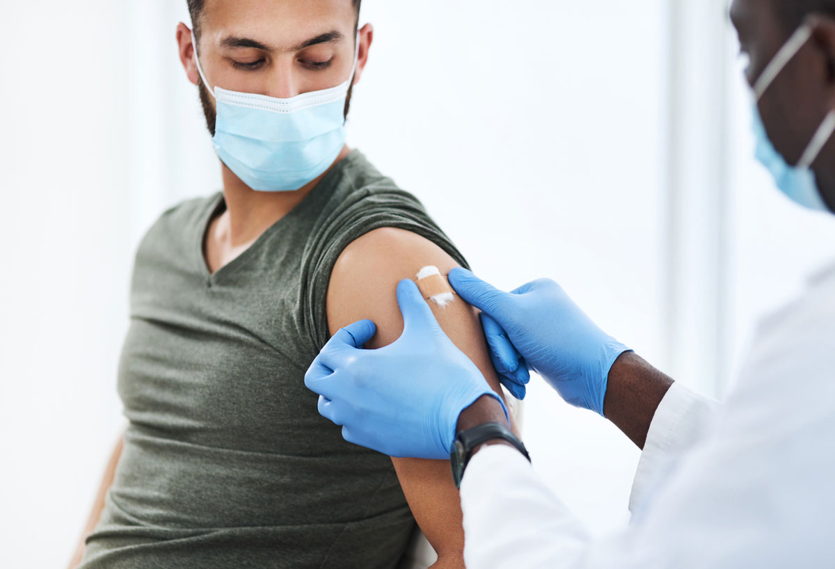 man getting vaccinated and band-aid placed