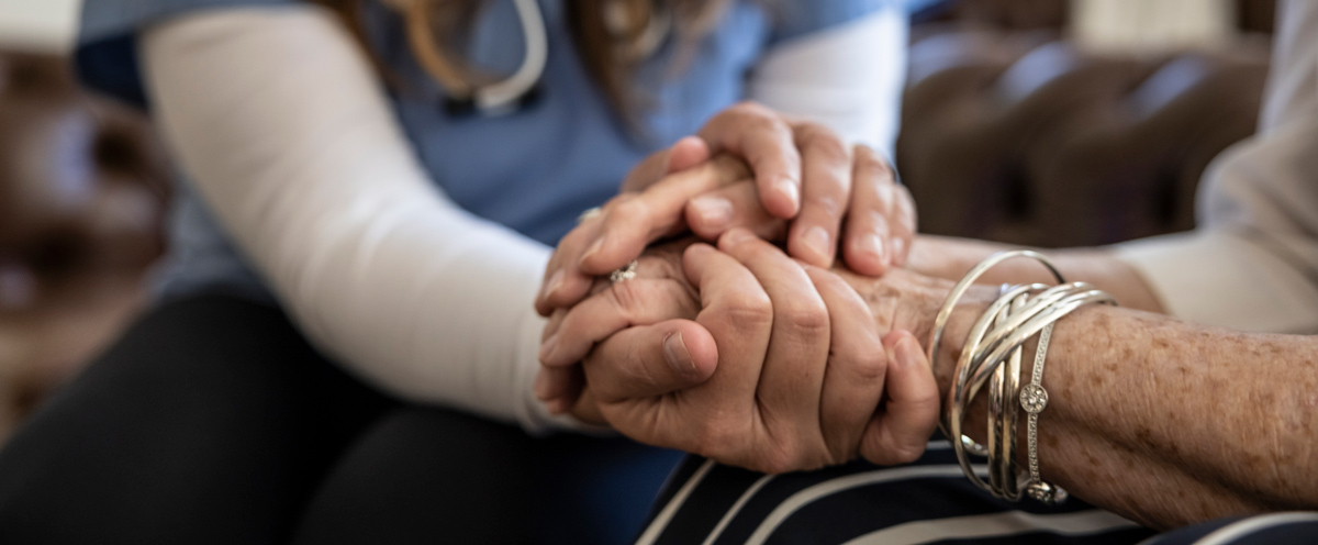 Caregiver holding a patient's hand